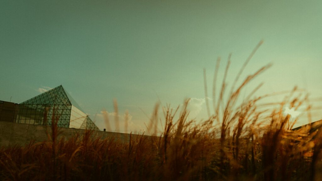 a building with a glass roof in the middle of a field